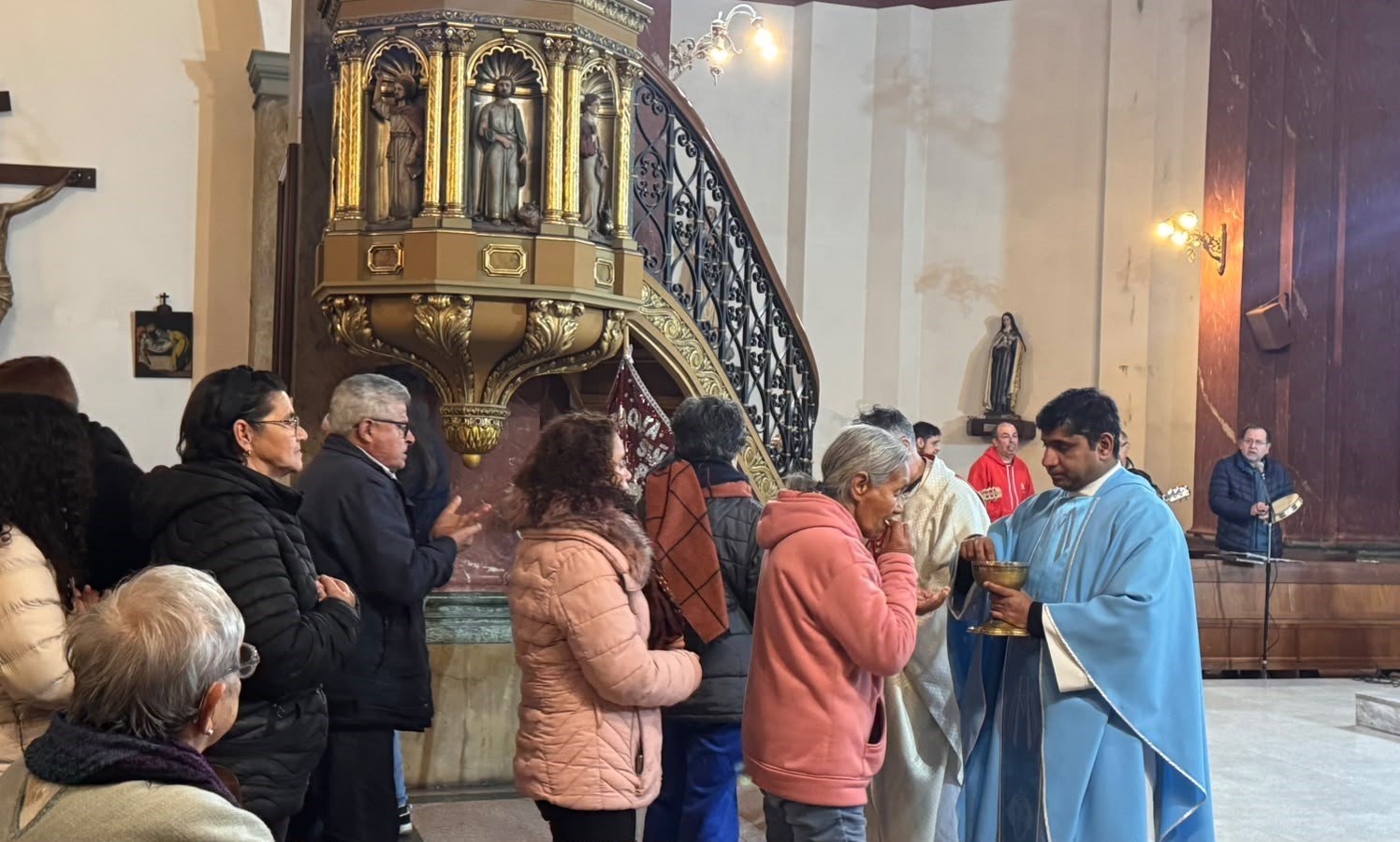 Sacerdote venerando la imagen de Ntra. Sra. de la Paz en el camarín